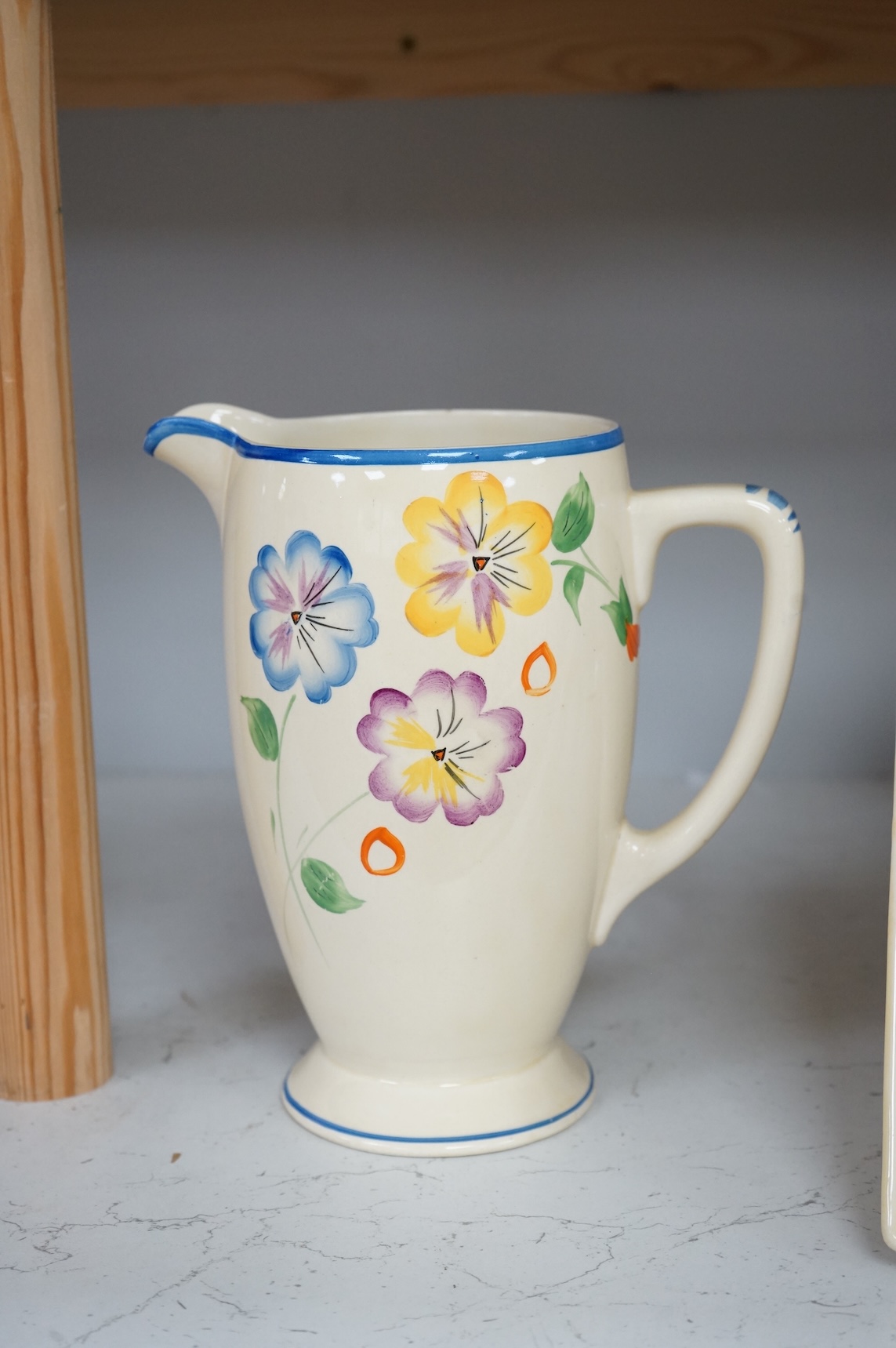Three Clarice Cliff Bizarre ‘Biarritz’ dishes and a Wilkinson floral jug, largest 23cm wide